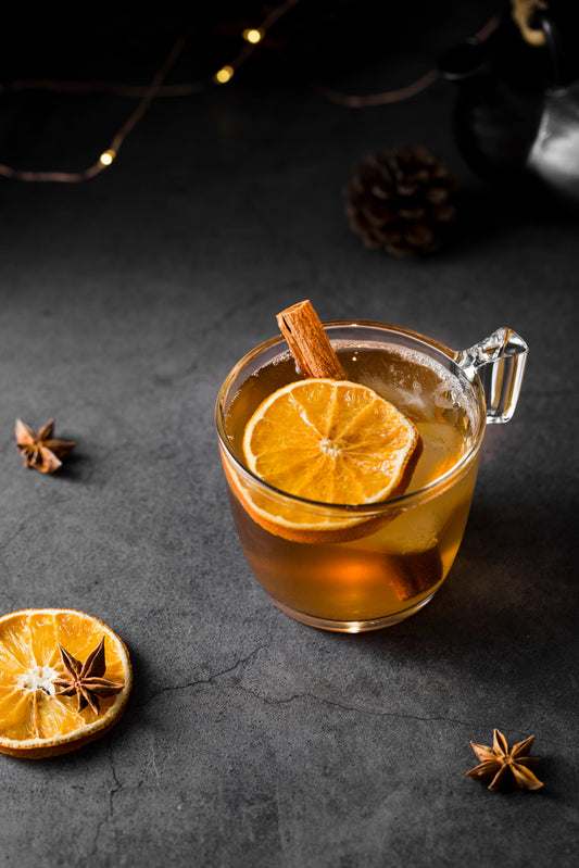 hot toddy with orange slice and cinnamon sticks