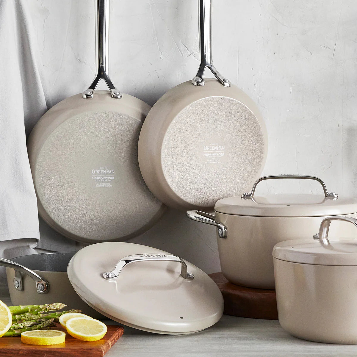 A set Green Pan GP5  ceramic nonstick cookware with mirror handles, including pots and pans with their respective lids, displayed on a kitchen counter.