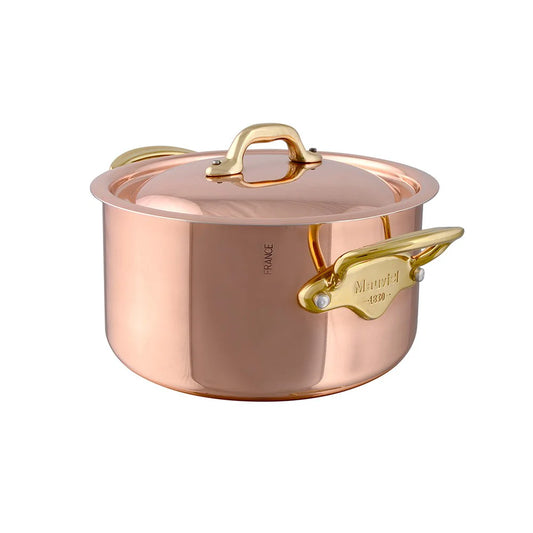 A copper stewpan with lid and brass handles.
