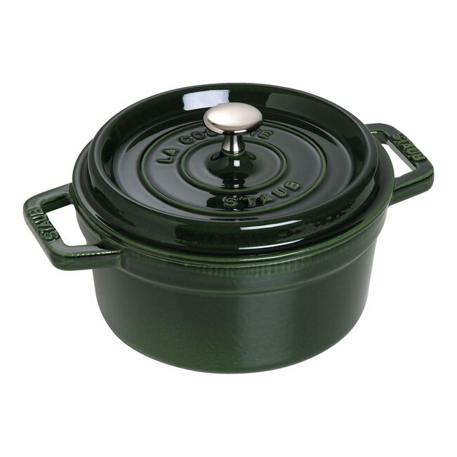 Green Staub cocotte with a lid on a white background